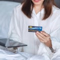 Woman using tablet and credit card for online shopping while making order on bed in morning at home. technology, ecommerce, Royalty Free Stock Photo
