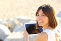 Woman using a tablet and looking at camera