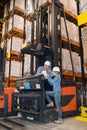 woman using tablet next to man on forklift Royalty Free Stock Photo