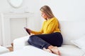 Woman using tablet sitting on sofa at living room Royalty Free Stock Photo