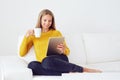 Woman using tablet sitting on sofa Royalty Free Stock Photo