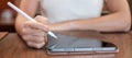 Woman using tablet for sms messages, hand holding pencil typing touchscreen mobile phone in cafe or modern office. lifestyle, Royalty Free Stock Photo