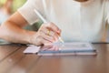 Woman using tablet for sms messages, hand holding pencil typing touchscreen mobile phone in cafe or modern office. lifestyle, Royalty Free Stock Photo