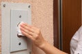 Woman using tissue paper to press elevator call button, closeup