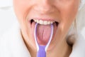 Woman using tongue cleaner