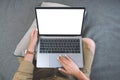 A woman using and touching on laptop touchpad with blank white screen while sitting in living room Royalty Free Stock Photo