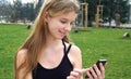 Woman using touchscreen phone outdoors in city park. Royalty Free Stock Photo