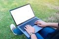 A woman using and typing on laptop with blank white screen and coffee cup on table in modern cafe Royalty Free Stock Photo