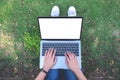 A woman using and typing on laptop with blank white screen and coffee cup on table in modern cafe Royalty Free Stock Photo