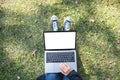 A woman using and typing on laptop with blank white screen while sitting in the outdoors Royalty Free Stock Photo