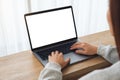 A woman using and typing on laptop computer with blank white desktop screen on wooden table Royalty Free Stock Photo