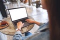 A woman using and typing on laptop computer keyboard with blank white desktop screen in cafe Royalty Free Stock Photo