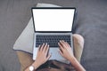 A woman using and typing on laptop keyboard with blank white screen while sitting in living room Royalty Free Stock Photo