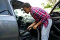 Woman using vacuum cleaner, hand car wash station