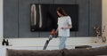 Woman using vacuum cleaner to clean floor in the living room at home. Cleaning home by using wireless vacuum cleaner Royalty Free Stock Photo