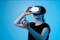 Woman using VR headset in profile while adjusting goggles and interacting with virtual environment Royalty Free Stock Photo