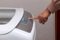 A woman using a washing machine. Hand pressing a button on the washing machine Royalty Free Stock Photo