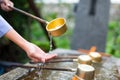 Woman using the water bamboo ladle for purification Royalty Free Stock Photo