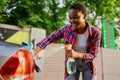 Woman using window cleaner spray, hand car wash