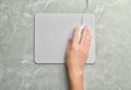 Woman using wired computer mouse on grey marble table, top view. Space for text Royalty Free Stock Photo