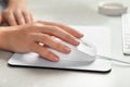 Woman using wired computer mouse on pad at grey marble table, closeup Royalty Free Stock Photo