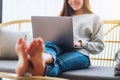 A woman using and working on laptop computer while lying on a sofa at home Royalty Free Stock Photo