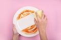 Woman using yellow cleaning sponge to clean up and washing food stains and dirt on white dish after eating meal Royalty Free Stock Photo