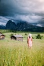 Woman on vacation in the Dolomites Italy,Alpe di Siusi - Seiser Alm with Sassolungo - Langkofel mountain group in