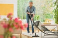 Woman is vacuuming beige carpet