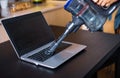 Woman vacuuming dust of a laptop