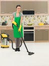 Woman vacuuming kitchen floor Royalty Free Stock Photo