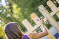 Woman varnishing a new wooden fence