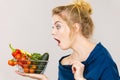 Woman with vegetables, shocked face expression