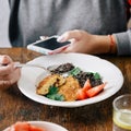 Woman vegetarian taking pictures food eats smartphone Royalty Free Stock Photo