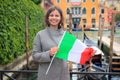 Woman in Venice with italian flag in hands. Girl on gondola in canal background. Happy tourist in Venezia, Italy