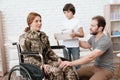 Woman veteran in wheelchair returned from army. The son and husband are happy to see her. Royalty Free Stock Photo