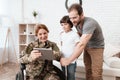 Woman veteran in wheelchair returned from army. The son and husband are happy to see her. Royalty Free Stock Photo