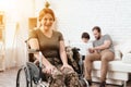 Woman veteran in wheelchair returned from army. A woman in a wheelchair is smiling. She put her hands on her legs