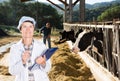 Woman veterinarian with clipboard on cow farm Royalty Free Stock Photo