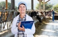 Woman veterinarian with clipboard on cow farm Royalty Free Stock Photo