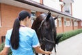 Woman veterinarian feeding horse from hand at ranch