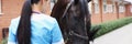 Woman veterinarian feeding horse from hand at ranch