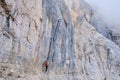 Woman on via ferrata ladder, on impressive tall rock wall at Tofana di Mezzo, Dolomites mountains, Italy. Adventure