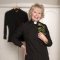 Woman vicar holding a sprig of Holly