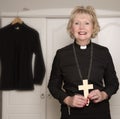 Woman vicar holding a wooden cross