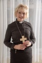 Woman vicar holding a wooden cross