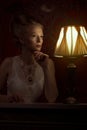 Woman in victorian style and vintage room with lamp beside her Royalty Free Stock Photo