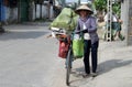 Woman in Vietnam wearing traditional triangular straw palm hats