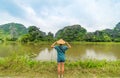 Woman with vietnamese hat looking at unique view of Tam Coc Trang An Ninh Binh tourist destination in Vietnam. Karst rock Royalty Free Stock Photo