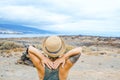 Woman viewed from back enjoy nature and scenic place with coastline and blue sky in background. Travel tourist people admiring